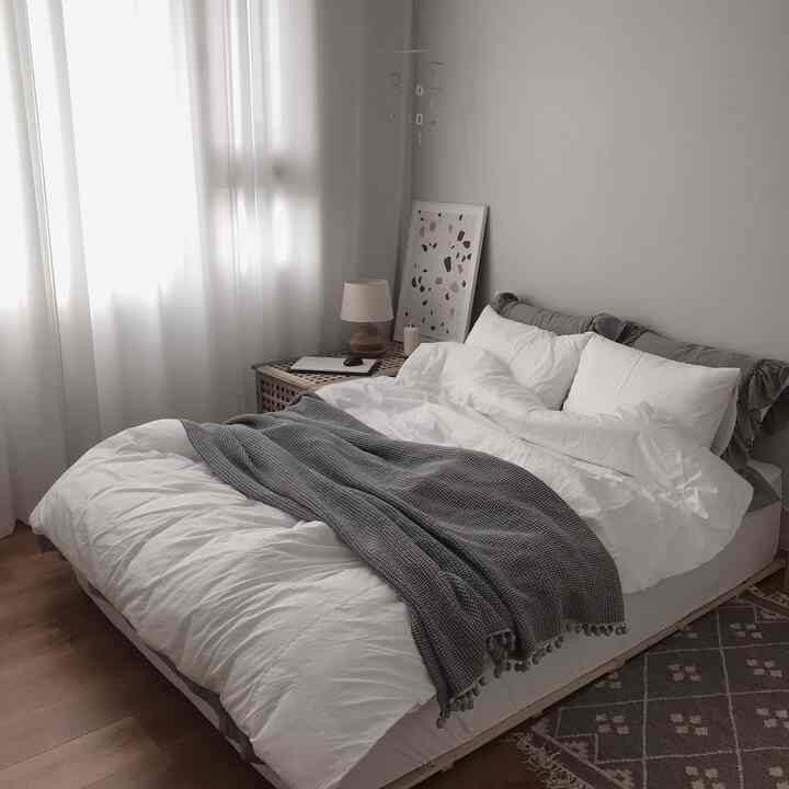 White and gray toned bedroom featuring modal bedding and gray throw, creating a clean, modern, and natural atmosphere