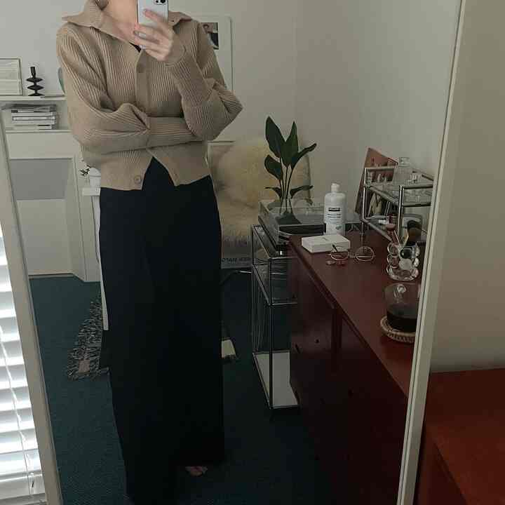 Compact room in beige and dark green tones featuring transparent modular shelving and a red storage cabinet with a simple interior