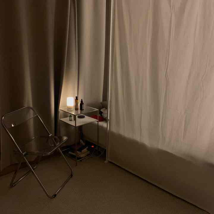 Beige and white toned studio bedroom featuring curtain partition and rug for cozy room division