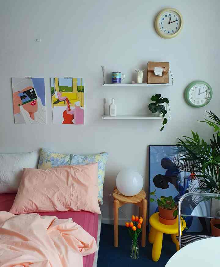 Cozy bedroom with white walls, wooden stool, and pink bedding