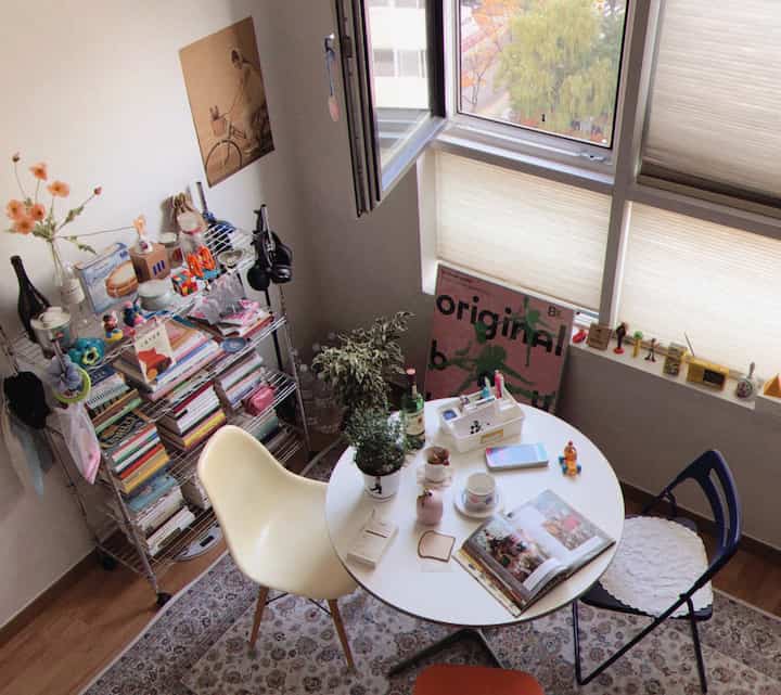 A cozy home cafe space featuring a white round table with chairs complemented by wood tones in a compact room with natural light.
