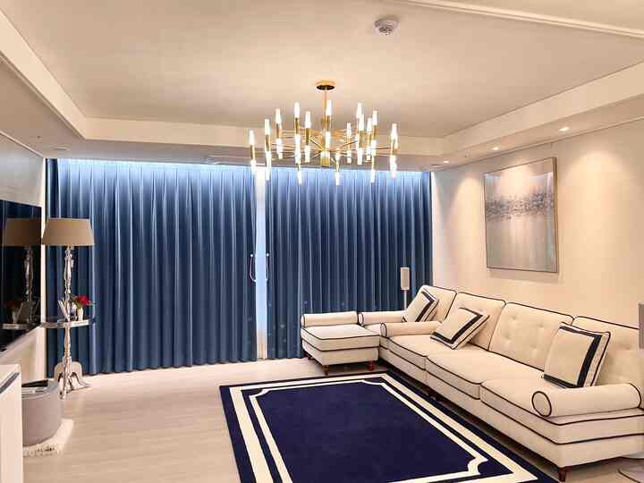 Modern living room with navy velvet curtains and beige sectional sofa