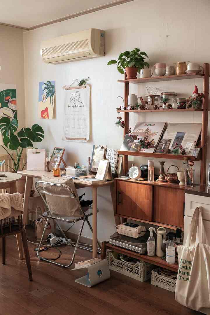 白い壁と木目調の家具が調和するワンルームの書斎、デスクと棚が温かみのある雰囲気を醸し出している