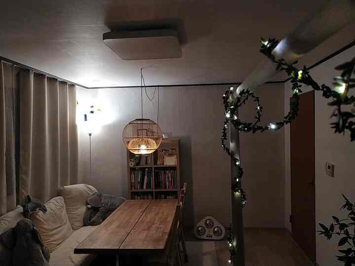 Beige sofa and wood-toned dining table in living room with cozy lighting creating warm atmosphere