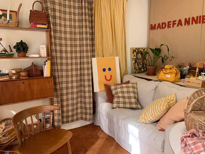 Cozy living room with beige and yellow tone curtains featuring wood-tone furniture and soft white sofa