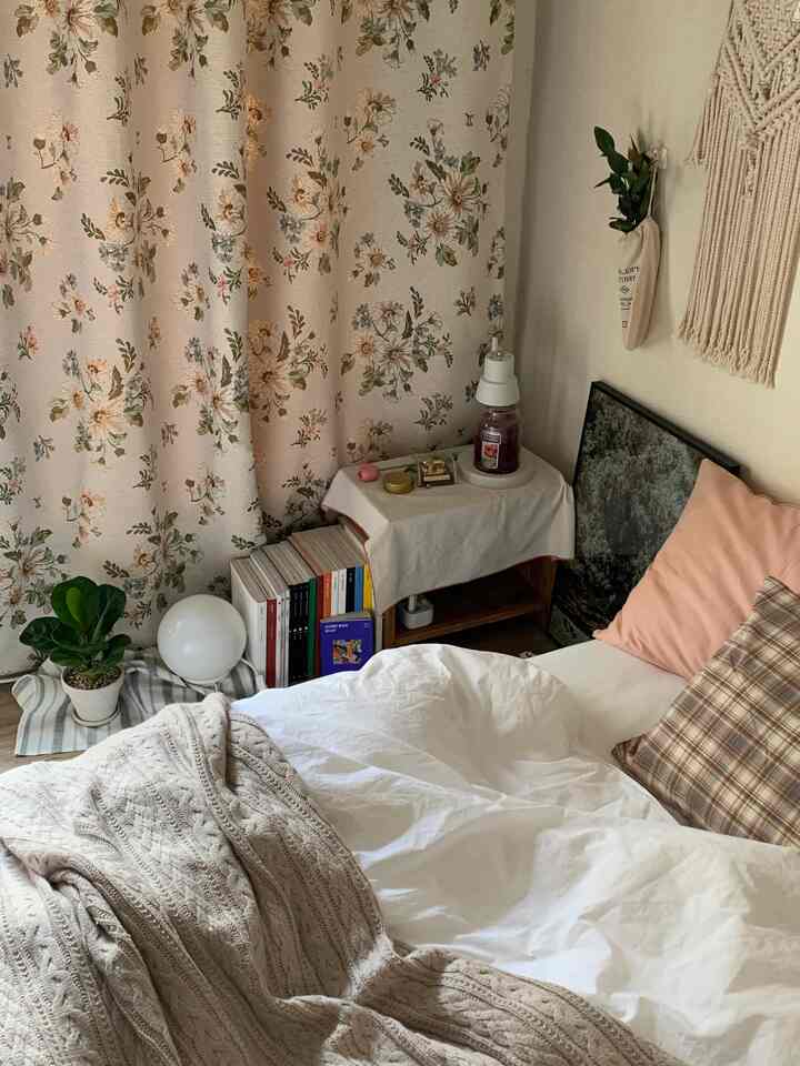 ベージュとホワイトのトーンの寝室、花柄カーテンと収納家具が配置された雰囲気のあるインテリア