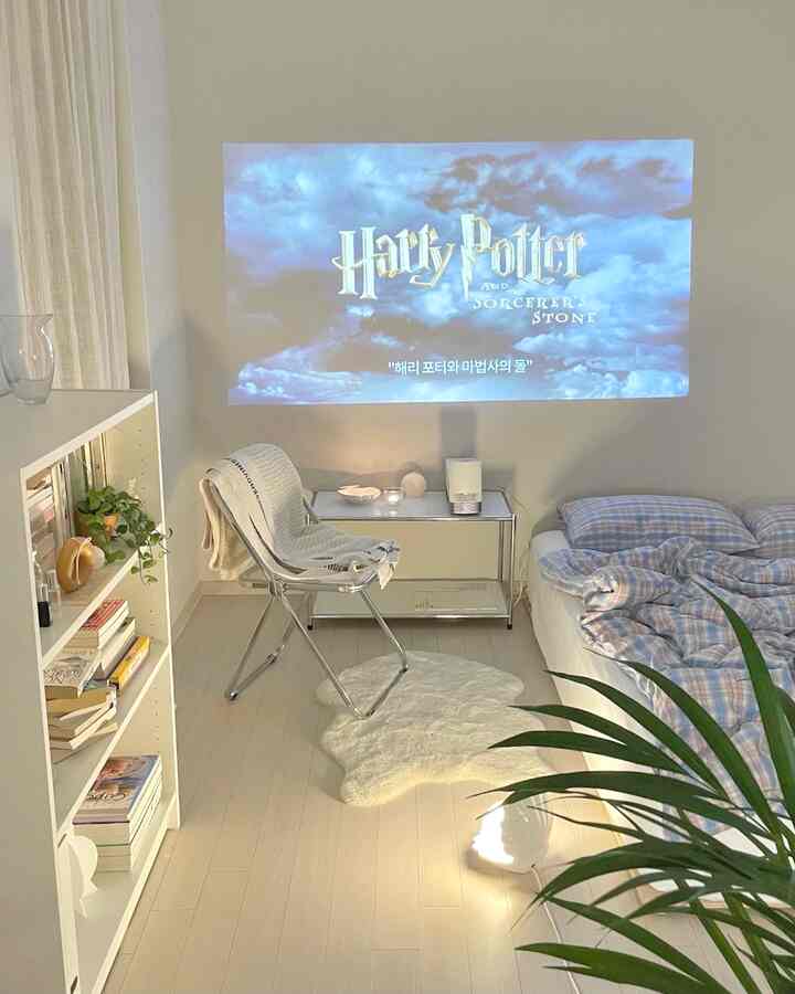 Bright white-toned bedroom featuring a beam projector screen and modern furniture creating a cozy atmosphere