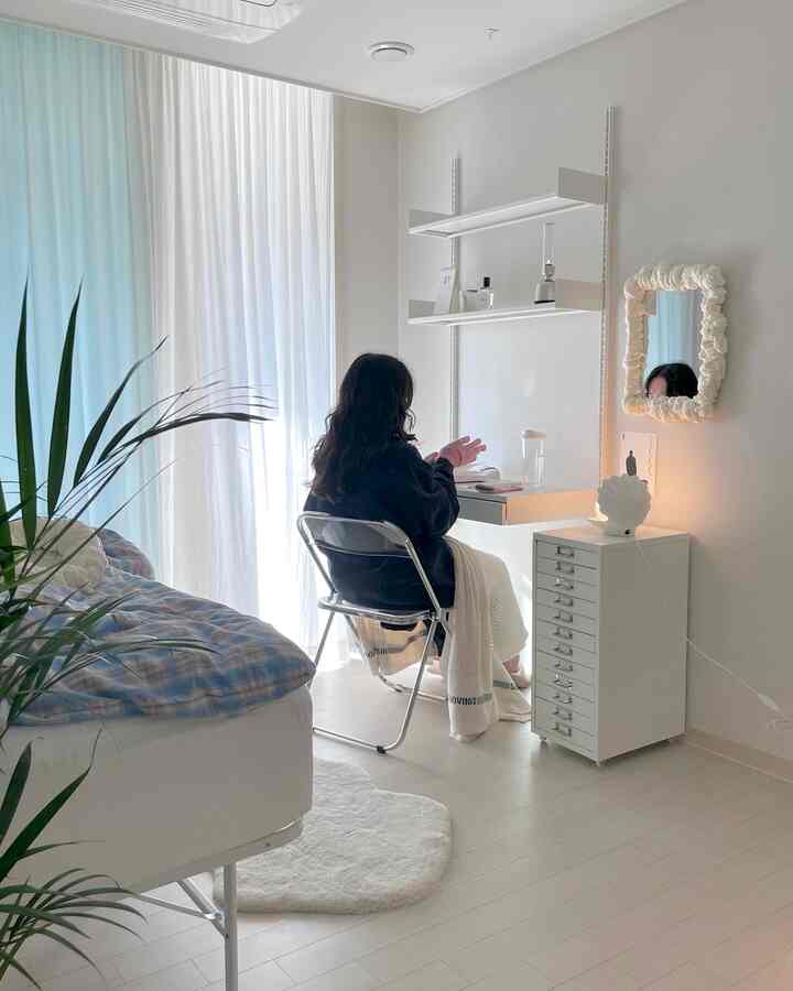 白と木目調の寝室、コンパクトなデスクとドレッサーが配置されたシンプルで自然な雰囲気のあるインテリア