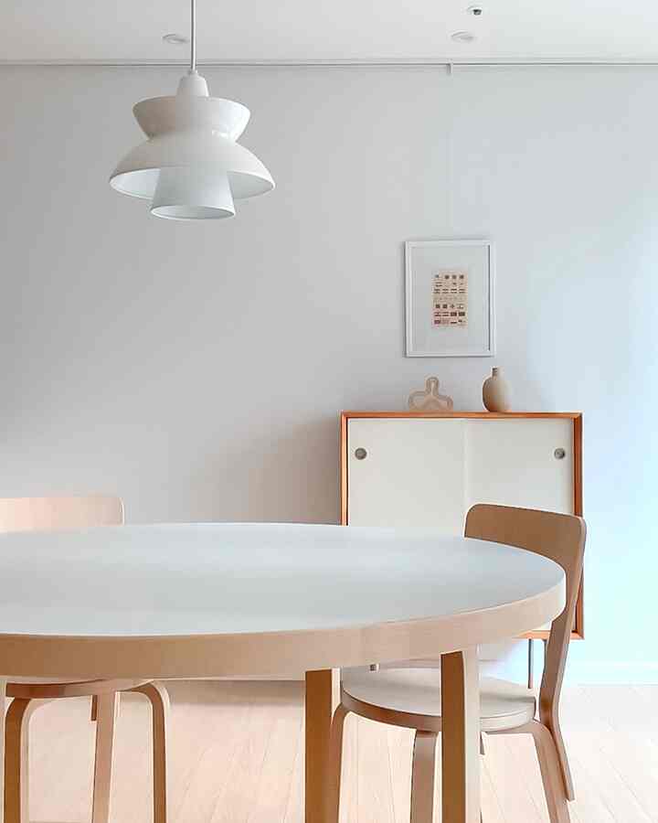 Bright dining room in white and natural wood tones featuring a round dining table and chairs with a clean atmosphere