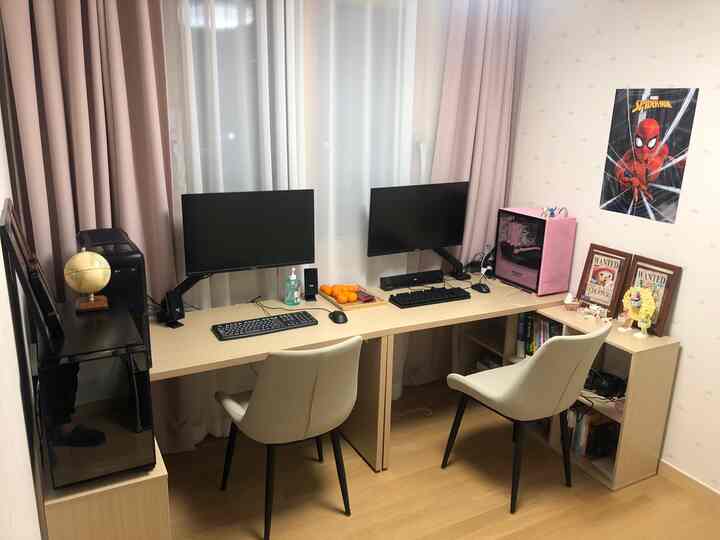 White and pink toned compact game room featuring two desks, dual monitors, and comfortable chairs for an efficient workspace