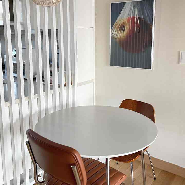 White and brown toned dining room featuring a round dining table and chairs with a modern, clean atmosphere
