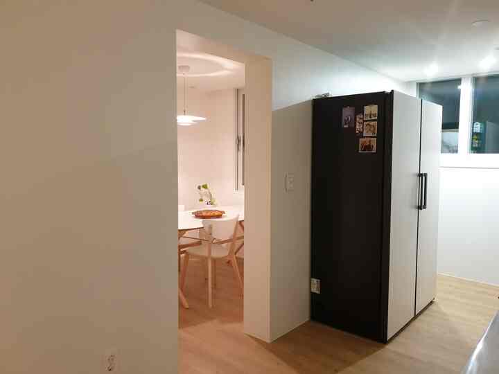 Small dining room in white and wood tones, featuring a simple and warm atmosphere