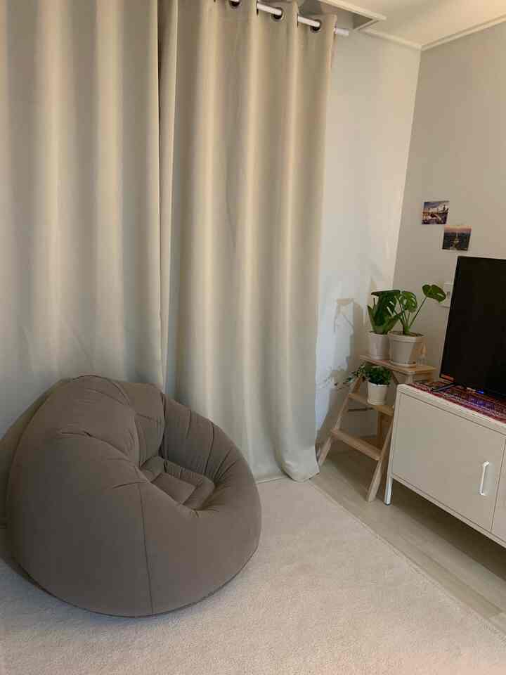 Ivory curtains and beige bean bag with plants arranged in a cozy living room space