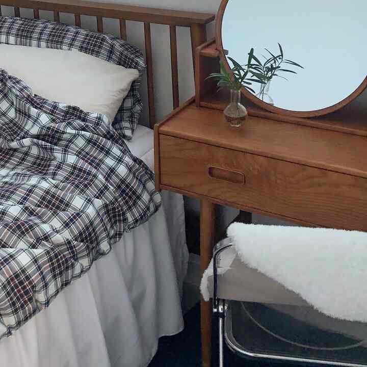 Natural wood tones and white blend in a bedroom featuring a bed frame and vanity, creating a cozy atmosphere