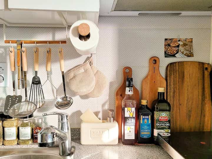 ナチュラルな木目調とベージュ色調のキッチン、整頓された調理器具とまな板が配置された雰囲気のある空間