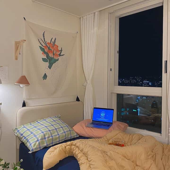 Loft bedroom in yellow and navy tones, featuring cozy duvet cover and fabric poster, creating a warm and inviting atmosphere