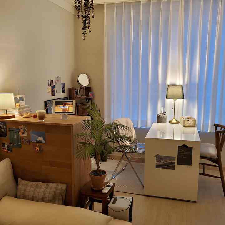 ナチュラルモダンスタイルのワンルームリビング、木目調家具と植物、白いダイニングテーブルが配置された雰囲気のあるインテリア