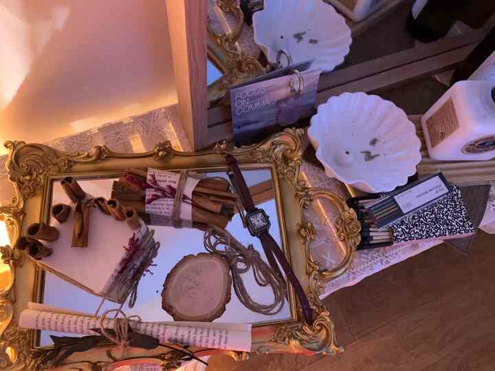 Warm-toned decorative space featuring gold antique mirror tray with watch, cinnamon sticks, and ribbons arranged