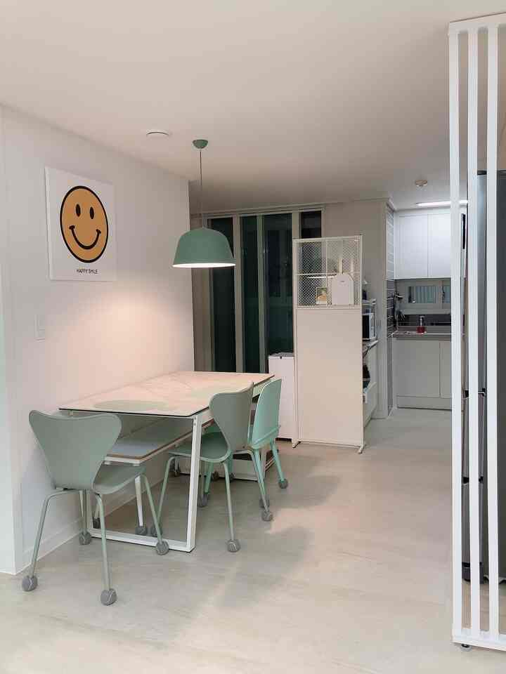 白とミント色調のダイニングルーム、シンプルなテーブルと椅子が配置された雰囲気のあるインテリア