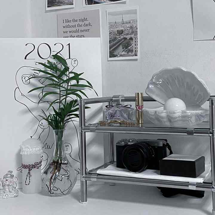 白とナチュラルカラーの小さな部屋、モジュラーシェルフと植物が配置されたミニマルで整ったインテリア