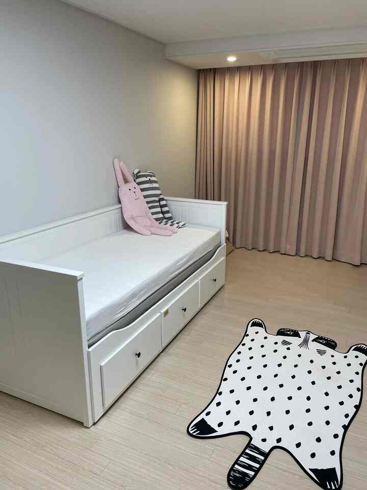 White and pink toned bedroom featuring a white bed frame and pink blackout curtains with cozy ambiance