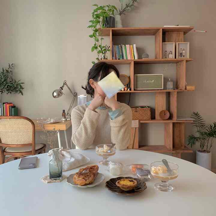 ベージュとホワイトの色調のリビング、丸いダイニングテーブルと自然素材の家具が配置された雰囲気のある空間