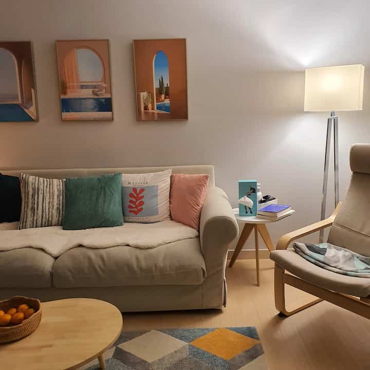 Natural Nordic living room with beige sofa and wood tone wooden table, creating a warm and cozy atmosphere