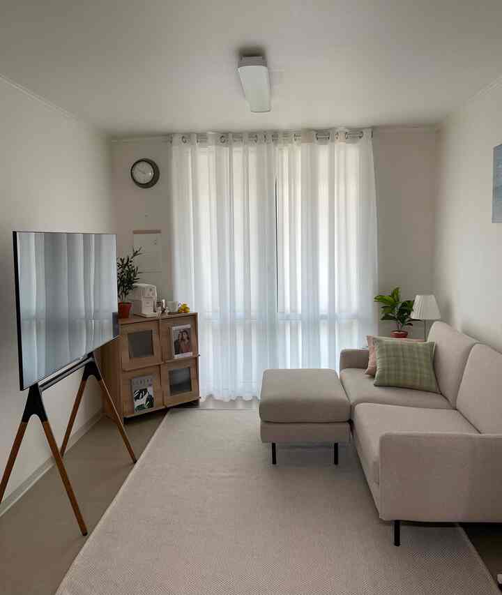 White and beige living room featuring beige sofa and TV stand with a natural modern atmosphere