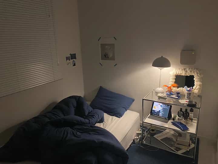 Navy and white toned bedroom featuring a small bed and minimalistic nightstand creating a cozy atmosphere