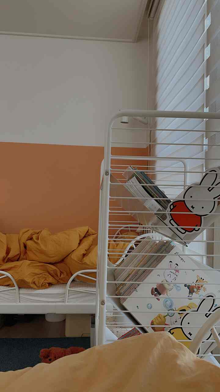 Kids' room with yellow bedding and white metal furniture, creating a cozy child-friendly space