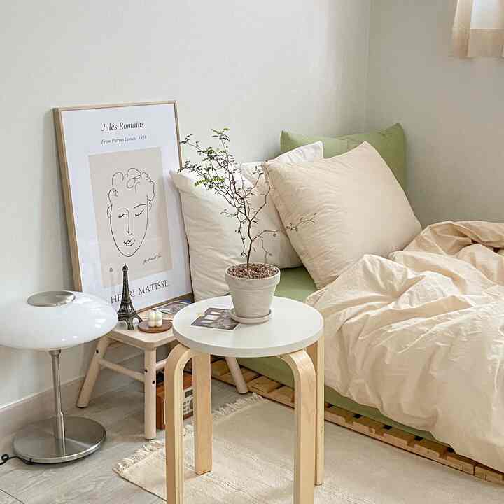Natural-toned bedroom featuring wooden bed frame and beige bedding arranged comfortably in a cozy space