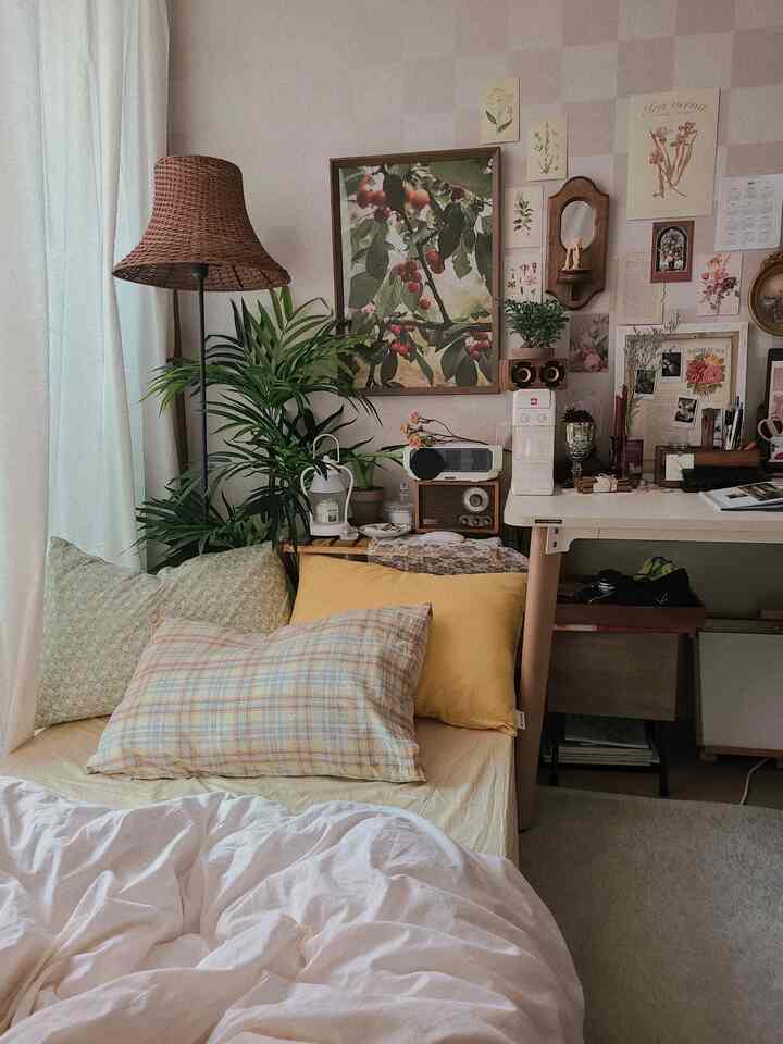 Natural wood tone and white-based bedroom featuring vintage posters and rattan lamp in a cozy studio apartment