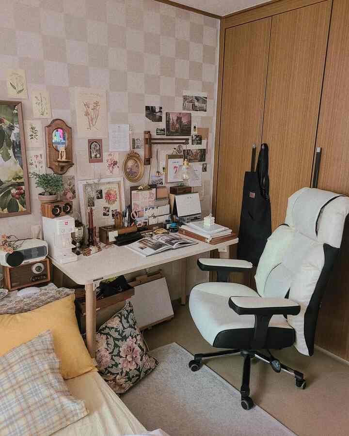 Cozy small workspace with ivory and wood tones, featuring a gaming chair and wall posters creating a vintage atmosphere