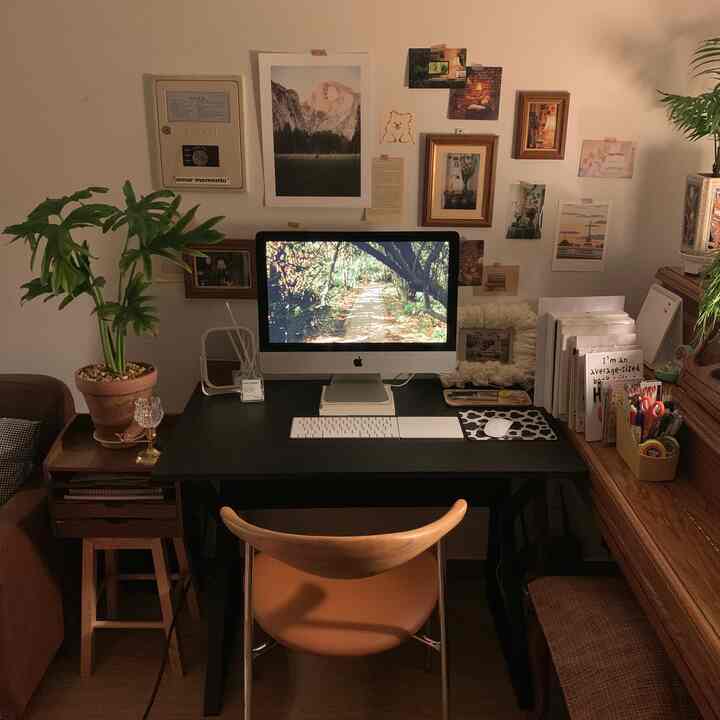 温かみのある木目調とナチュラルモダンが融合したコンパクトなホームオフィス、デスクや植物、壁飾りが調和した印象的な空間