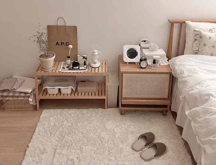 White and brown toned bedroom featuring wooden bed, nightstand, and fluffy rug with a calm natural atmosphere