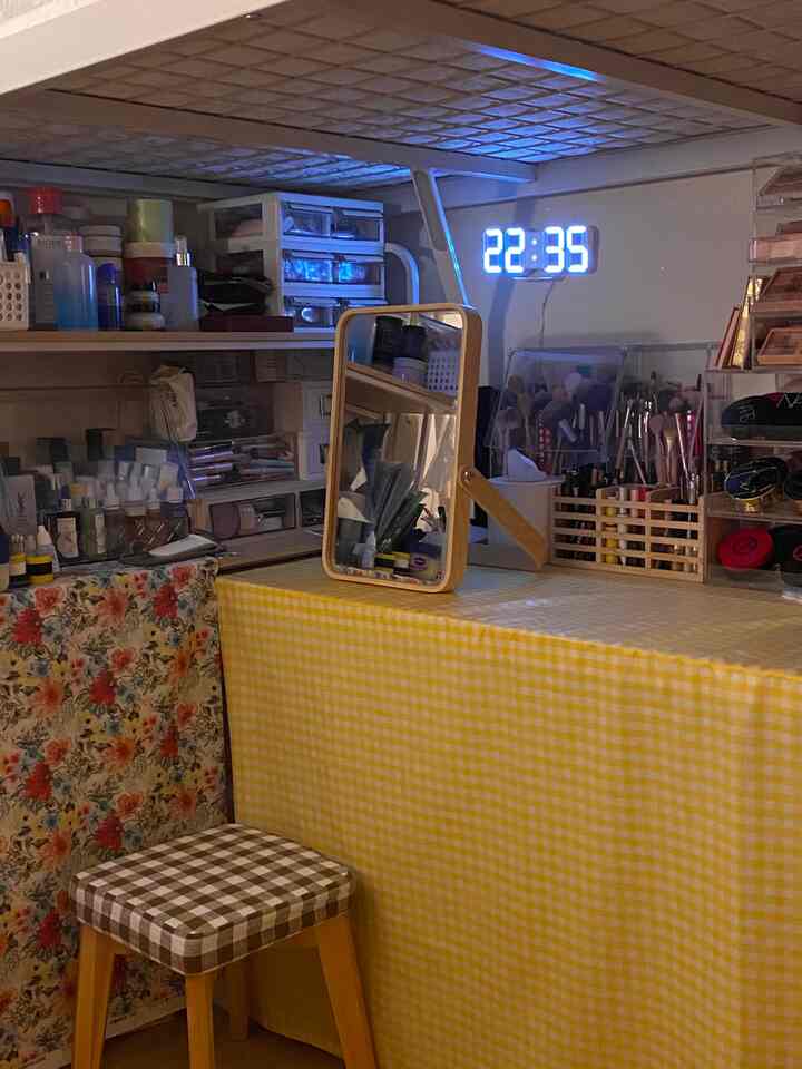 Yellow tablecloth and wooden framed mirror in a compact vanity space, neat with a natural atmosphere