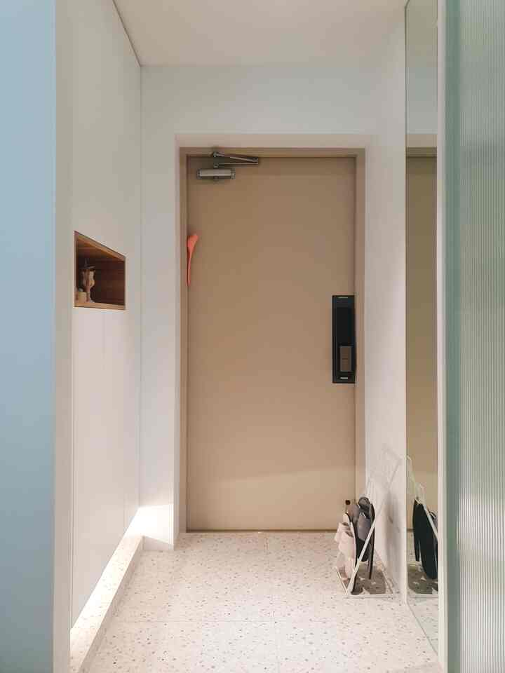 明るいベージュの玄関扉と白いシューズラックがあるすっきりとした玄関スペース