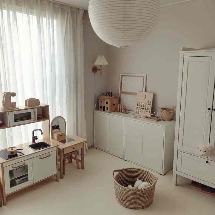 ベージュとナチュラルカラーの子供部屋、木製家具と収納キャビネットが配置された雰囲気のあるインテリア