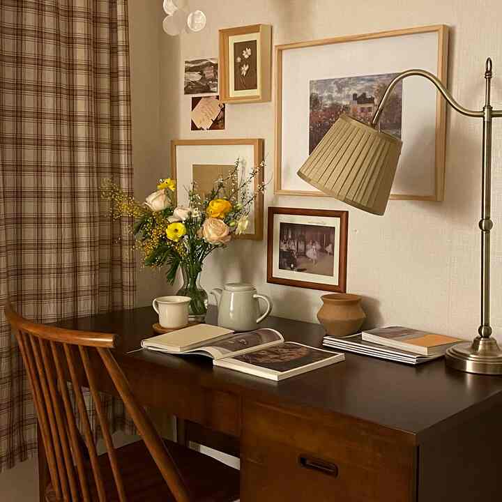 Brown and beige toned bedroom desk space featuring vintage lamp and vase, creating a cozy and warm atmosphere