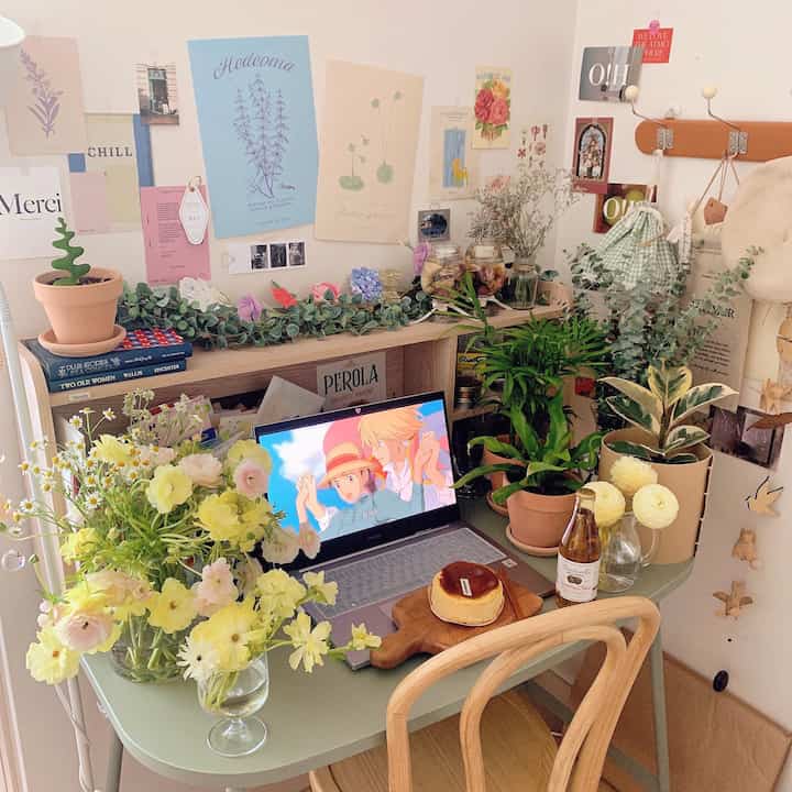 Pastel tone and natural color home office space featuring a desk with abundant flowers and plants, evoking spring ambiance