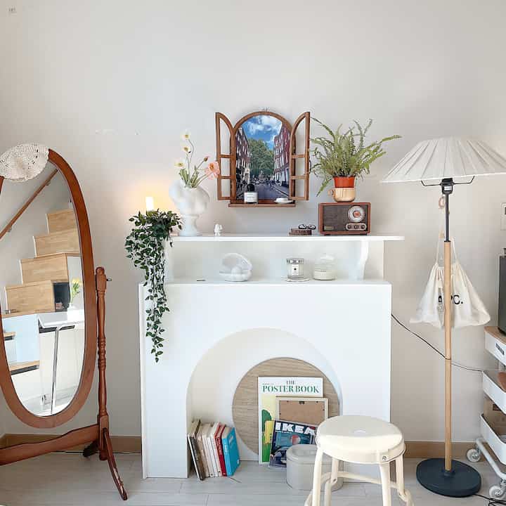 A white and wood-toned living room featuring a picture frame and floor lamp with a neat, simple ambiance