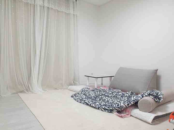 White and beige toned small room featuring a low table and armchair in a natural cafe style setting
