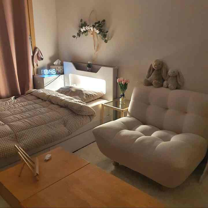 Beige and white toned bedroom featuring a single bed and white sofa in a cozy setting