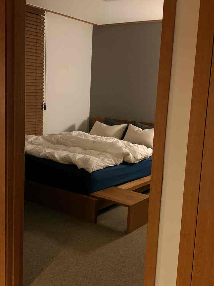 ナチュラルな木目調と青いマットレスが調和した寝室のインテリア