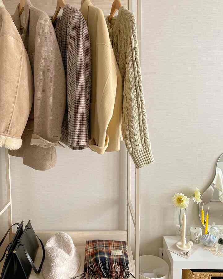 Natural color walled closet space with an open clothes rack featuring organized garments and accessories creating a tidy atmosphere