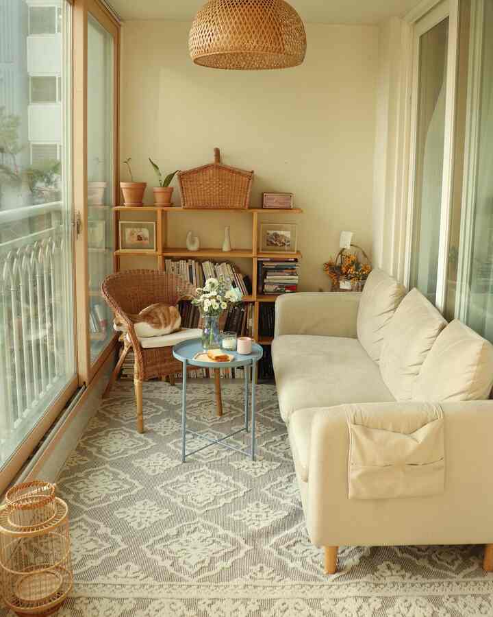 Beige and wood tones blend in a compact single household living room with armchair and sofa creating a cozy home cafe space