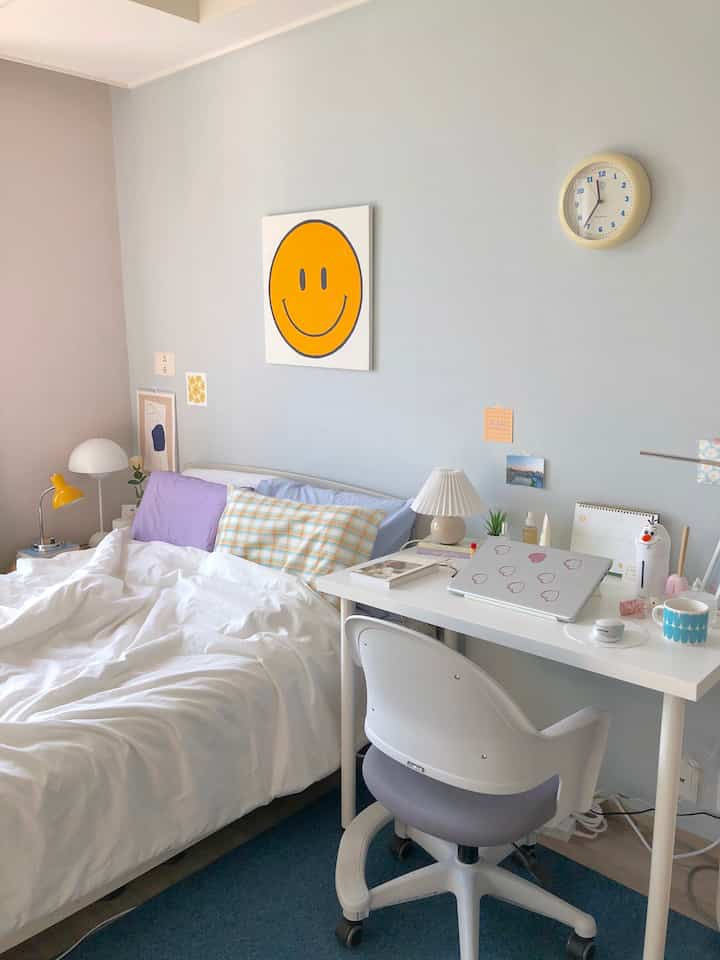Pastel-toned walls in a simple bedroom featuring a desk and chair creating a cozy space