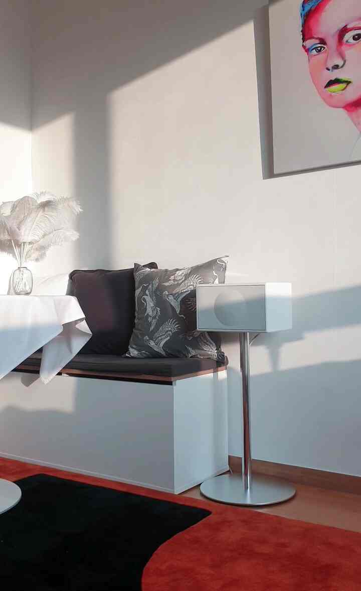 オレンジと黒のカーペット、白いベンチが配置されたナチュラルな雰囲気のワンルームリビング