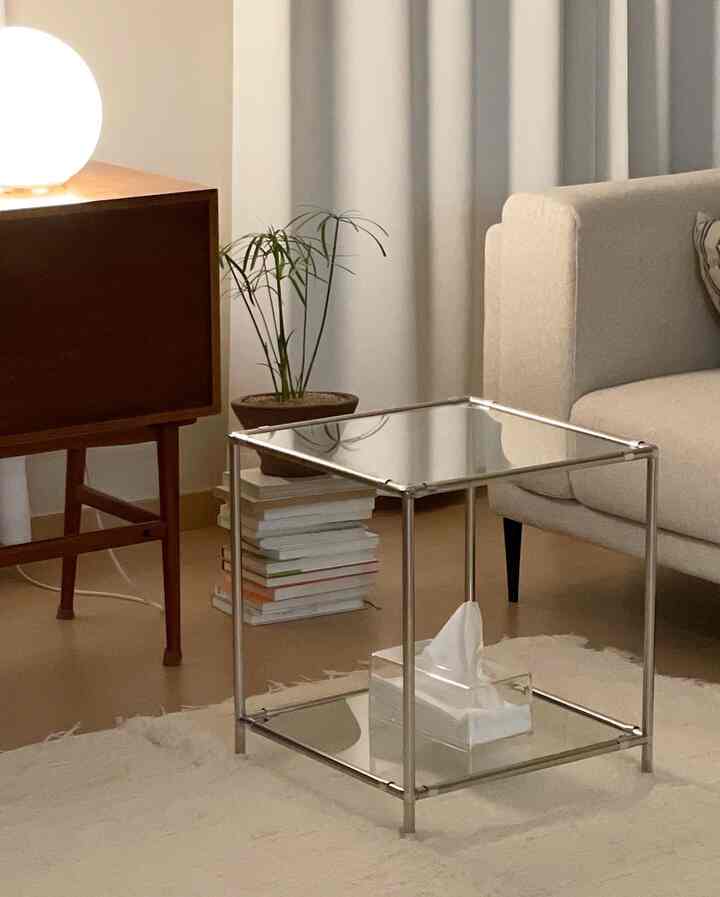 Beige and natural toned living room featuring metal frame side table and wooden cabinet, creating a soft, cozy atmosphere