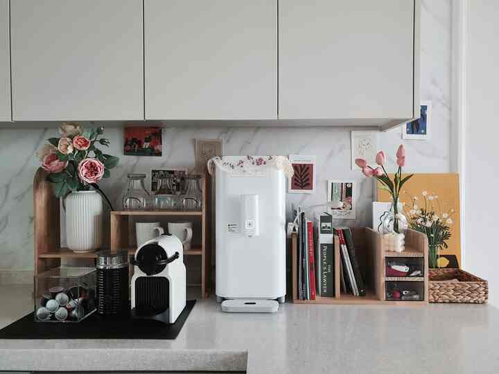 白と木目調のキッチン空間、コーヒーマシンと花瓶が整然と配置された清潔感のあるおうちカフェの雰囲気